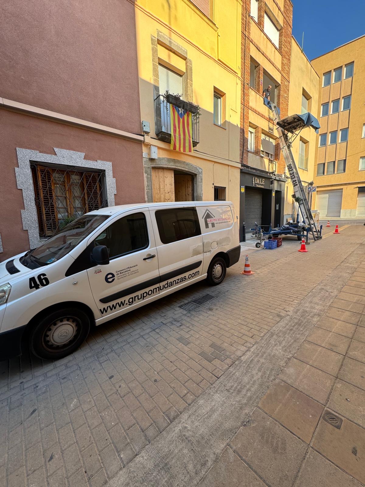 Elevador para mudanzas de Grupo Mudanzas realizando la subida de mobiliario por fachada en Barcelona