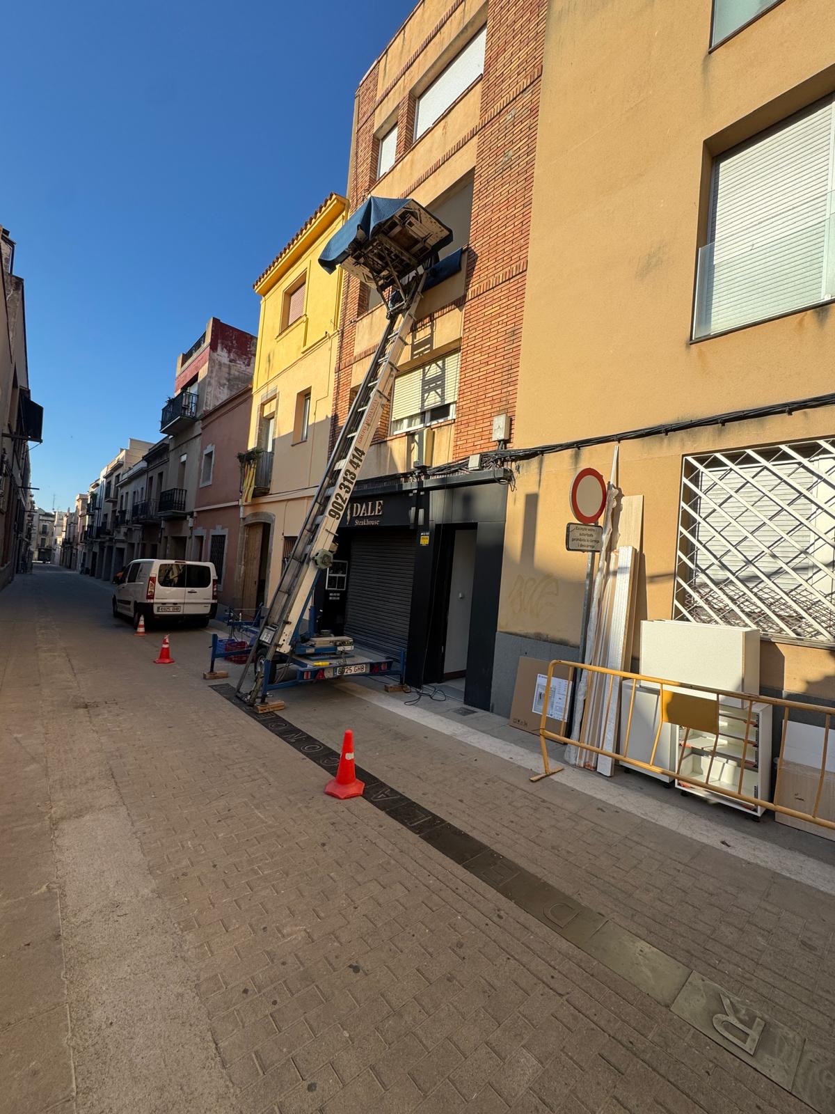 Elevador para mudanzas subiendo mobiliario por fachada en Mataró